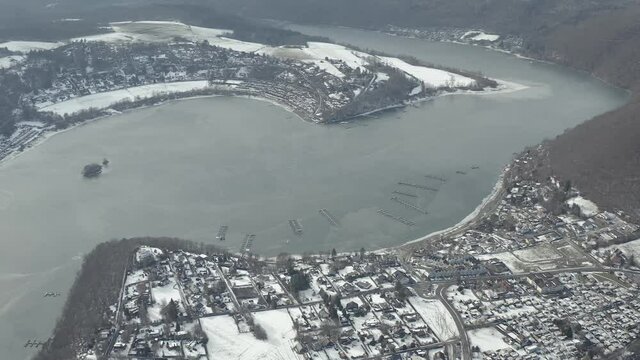 Drone Aerial views of the Keller National Park in Winter. The barrier lake Edersee is partly frozen. The Ederstausee is located in Hesse near the town Waldeck in Germany, Europe.