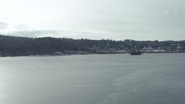 Drone Aerial views of the Keller National Park in Winter. The barrier lake Edersee is partly frozen. The Ederstausee is located in Hesse near the town Waldeck in Germany, Europe.