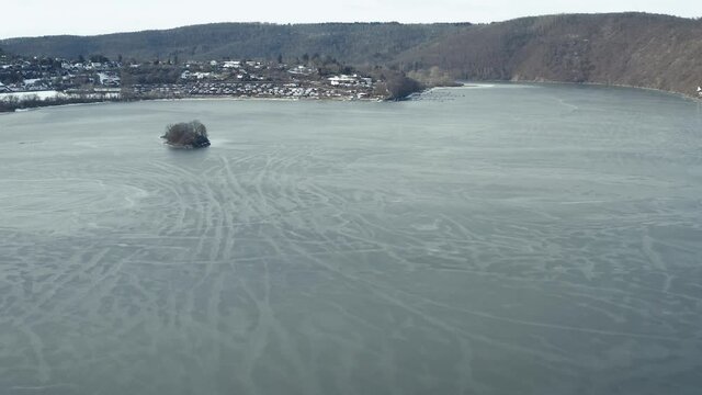 Drone Aerial views of the Keller National Park in Winter. The barrier lake Edersee is partly frozen. The Ederstausee is located in Hesse near the town Waldeck in Germany, Europe.