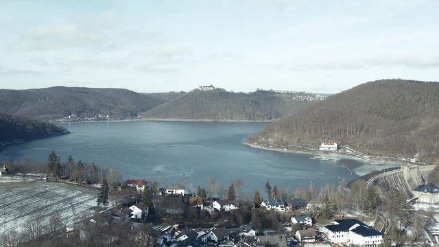 Drone Aerial views of the Keller National Park in Winter. The barrier lake Edersee is partly frozen. The Ederstausee is located in Hesse near the town Waldeck in Germany, Europe.
