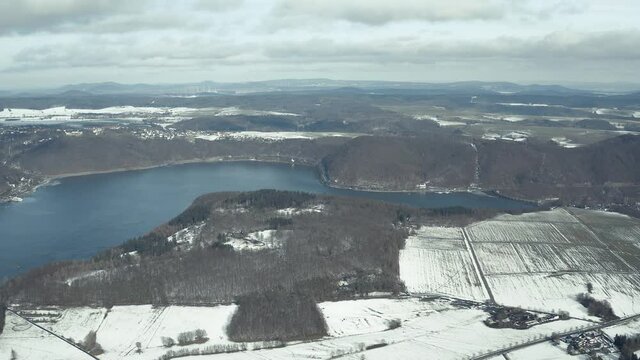 Drone Aerial views of the Keller National Park in Winter. The barrier lake Edersee is partly frozen. The Ederstausee is located in Hesse near the town Waldeck in Germany, Europe.