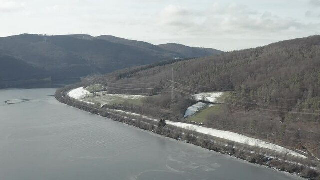 Drone Aerial views of the Keller National Park in Winter. The barrier lake Edersee is partly frozen. The Ederstausee is located in Hesse near the town Waldeck in Germany, Europe.