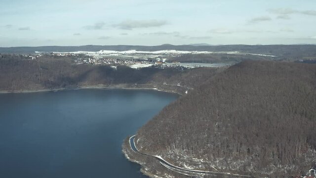 Drone Aerial views of the Keller National Park in Winter. The barrier lake Edersee is partly frozen. The Ederstausee is located in Hesse near the town Waldeck in Germany, Europe.