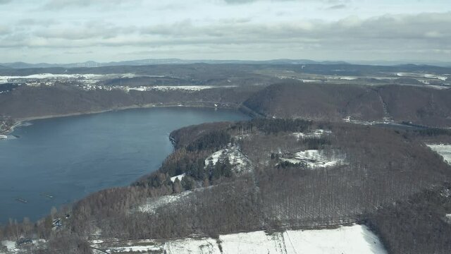 Drone Aerial views of the Keller National Park in Winter. The barrier lake Edersee is partly frozen. The Ederstausee is located in Hesse near the town Waldeck in Germany, Europe.