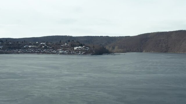 Drone Aerial views of the Keller National Park in Winter. The barrier lake Edersee is partly frozen. The Ederstausee is located in Hesse near the town Waldeck in Germany, Europe.