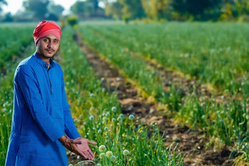 Young indian farmer at onion agriculture field