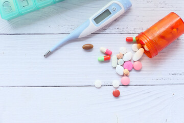 container, thermometer , pills and capsules on table 