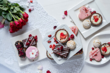 beautiful tasty romantic selection of pink chocolate love heart shape cakes for wedding, mothers day,  valentines day, spring flower biscuits tartlet and rose petals 