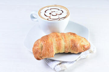 Cup of Colombian coffee, accompanied by baked bakery on white wooden background