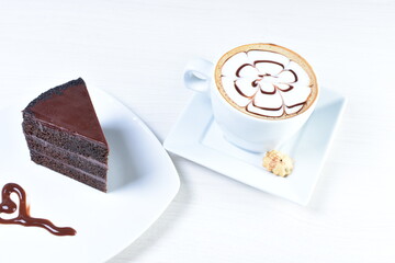 Cup of Colombian coffee, accompanied by baked cake on white wooden background