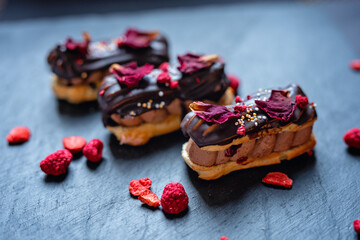 creamy chocolate eclair with edible flowers rose petals, romantic sweet dessert valentines day, wedding cake 