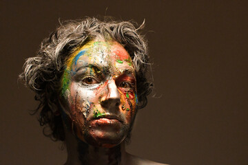 model with colorful face painting in darkness
