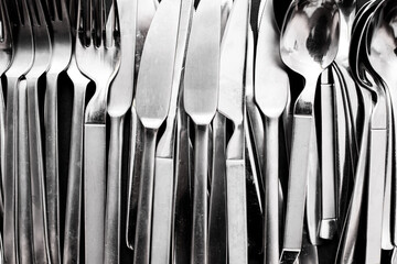 Simple style stainless steel cutlery viewed from above isolated on black background.