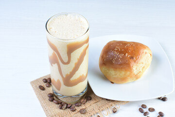 Colombian coffee milkshake, accompanied by baked bakery on white wooden background