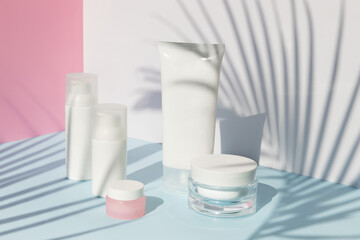 Care products set with palm leaf shadow. Summer body care beauty treatment