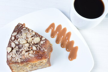 Cup of Colombian coffee, accompanied by baked cake on white wooden background