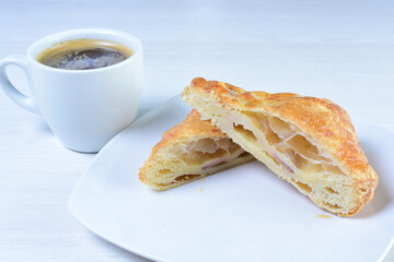 Cup of Colombian coffee, accompanied by baked bakery on white wooden background