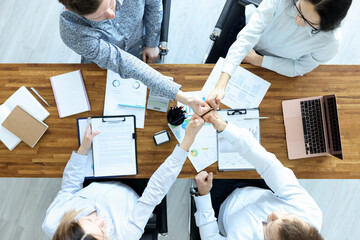 Group of business people sitting at table and showing thumbs up top view
