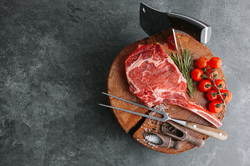 on a wooden block for meat a fresh raw tamahawk steak or a cowboy steak with a butcher's chopping...