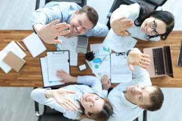 Group of business people sitting at table and waving their hands top view