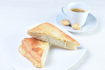Cup of Colombian coffee, accompanied by baked bakery on white wooden background