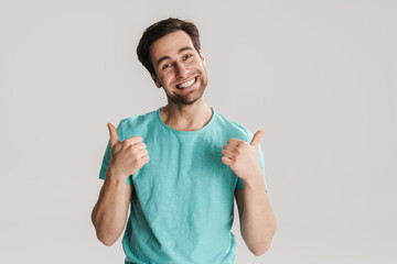 Joyful handsome guy smiling and showing thumbs up