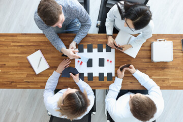 Group of people sitting at table and playing board games top view