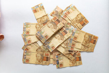 Obraz na płótnie Canvas Money from Brazil. Notes of Real, Brazilian currency. Hundred reais notes, background use red. Concept of economy, inflation and business. 