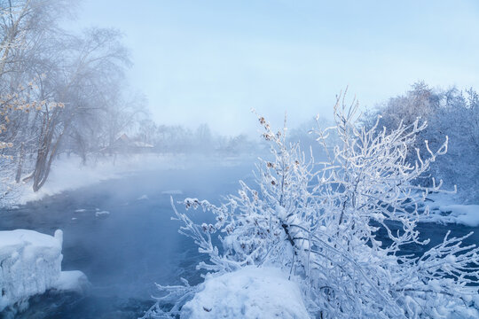 severe frost minus 30 degrees winter Urals, river with fog over it, frozen frost branches