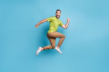 Fototapeta na wymiar Full body profile side photo of crazy funky positive man jump up run empty space isolated on blue color background