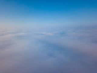 Flight high above the clouds. Aerial drone view.