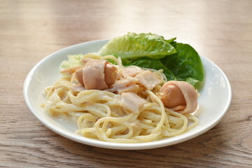 spaghetti carbonara topping slice ham pork and fresh cos lettuce vegetable on plate
