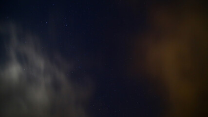 Long exposure of moving clouds on starry sky