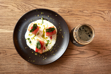 Delicious salmon in restaurant on a wooden table, no people are visible. Tasty seafood with beer in cafe or pub menu.
