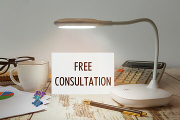 Desktop with a lamp that illuminates the inscription Free Consultation