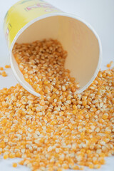 Pile of raw corns out of box on white background