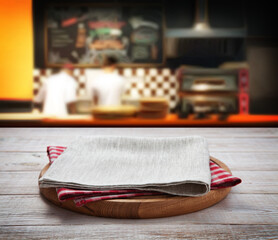 Napkin and board for pizza on wooden desk. Pizzeria background.