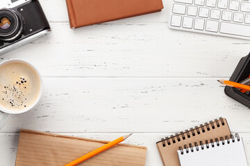 Office desk with supplies and photo camera