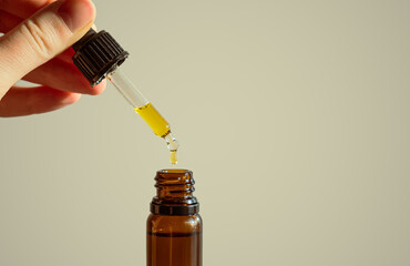 Dropper of cbd or thd oil in human hands. Essential oil, natural health products, calming supplements - obrazy, fototapety, plakaty
