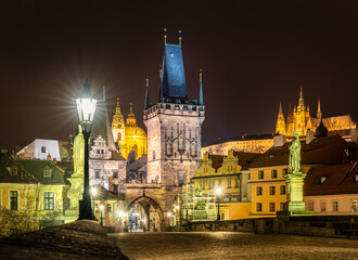 Prague, Czech Republic-January 31, 2019. Night view of the famous, historical Charles Bridge over the Vltava river, The Lesser Town Bridge Tower and Prague Castle on the hill in old Prague town.