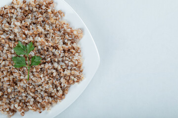 Delicious buckwheat with greens on a white plate