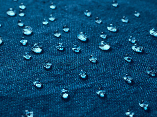 Water drops on blue waterproof fabric.