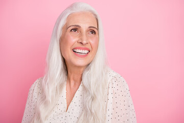 Portrait of attractive cheerful dreamy grey-haired woman laughing funny joke isolated over pink pastel color background