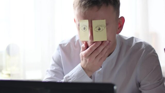Unloved uninteresting job. Sleepy worker with drawn eyes on paper falls asleep in office