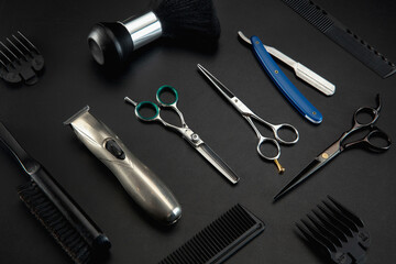 Barber shop equipment set isolated on black table background. Close up sccissors, comb, brushes, razors, professional tools of hairdresser. Professional occupation, art, self-care concept. Magazine.