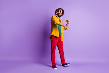 Full length portrait of carefree cheerful dark skin guy dancing partying have good mood isolated on purple color background