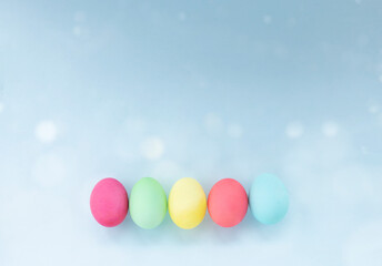 Fototapeta na wymiar easter eggs dyed in pastel colors against light blue background. Image with copy space