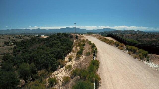 Aerial view of Nogales border area showing border fence separating the United States of America and Mexico with U.S. Border and Customs Protection patrolling border area with their vehicles