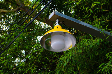 Yellow street lamp in garden.
