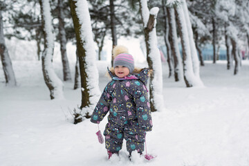 Fototapeta na wymiar Little girl in winter in a snow-covered forest.